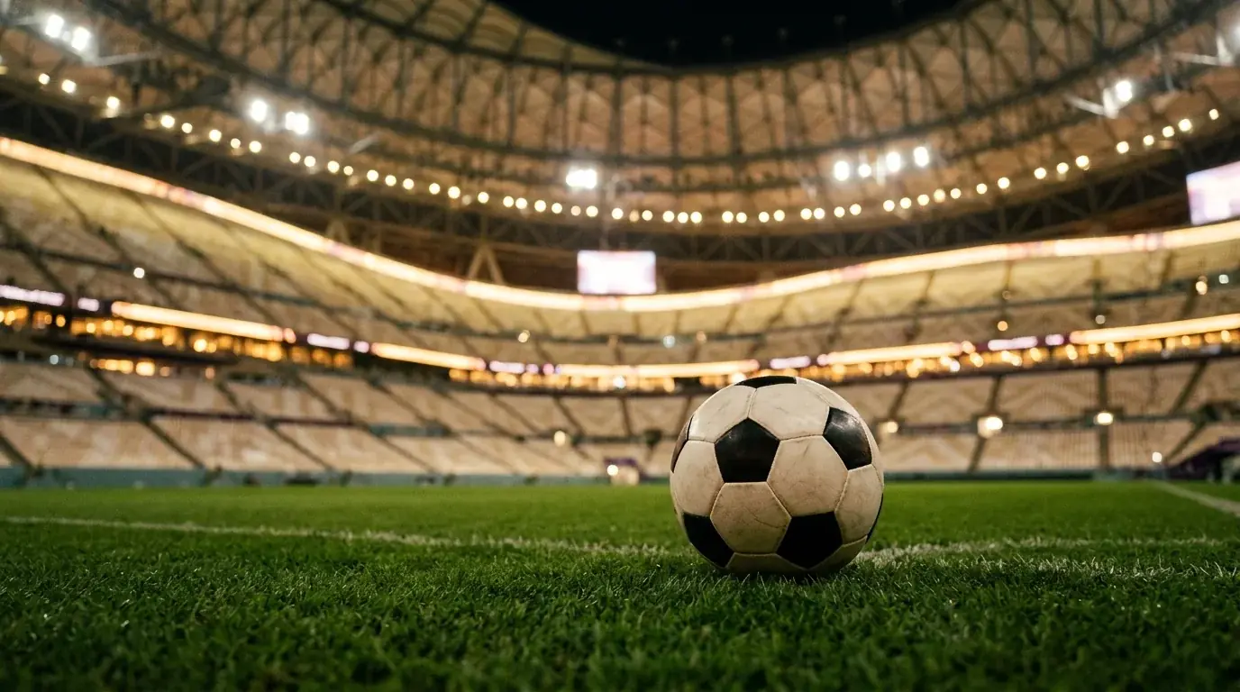 Ballon de football sur la pelouse d'un stade couvert, ambiance de soirée de demi-finale